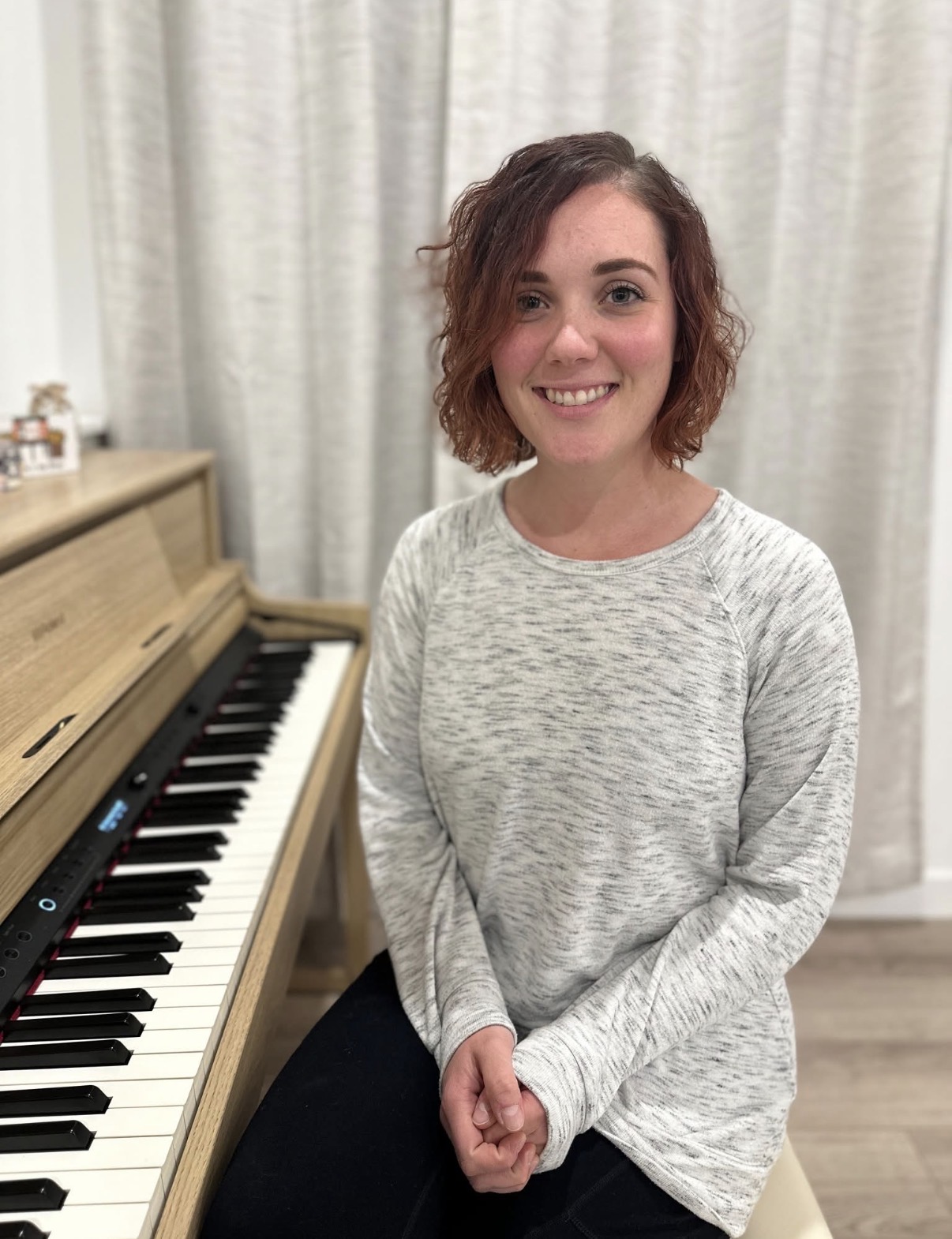 Kate seated beside the piano in her teaching studio